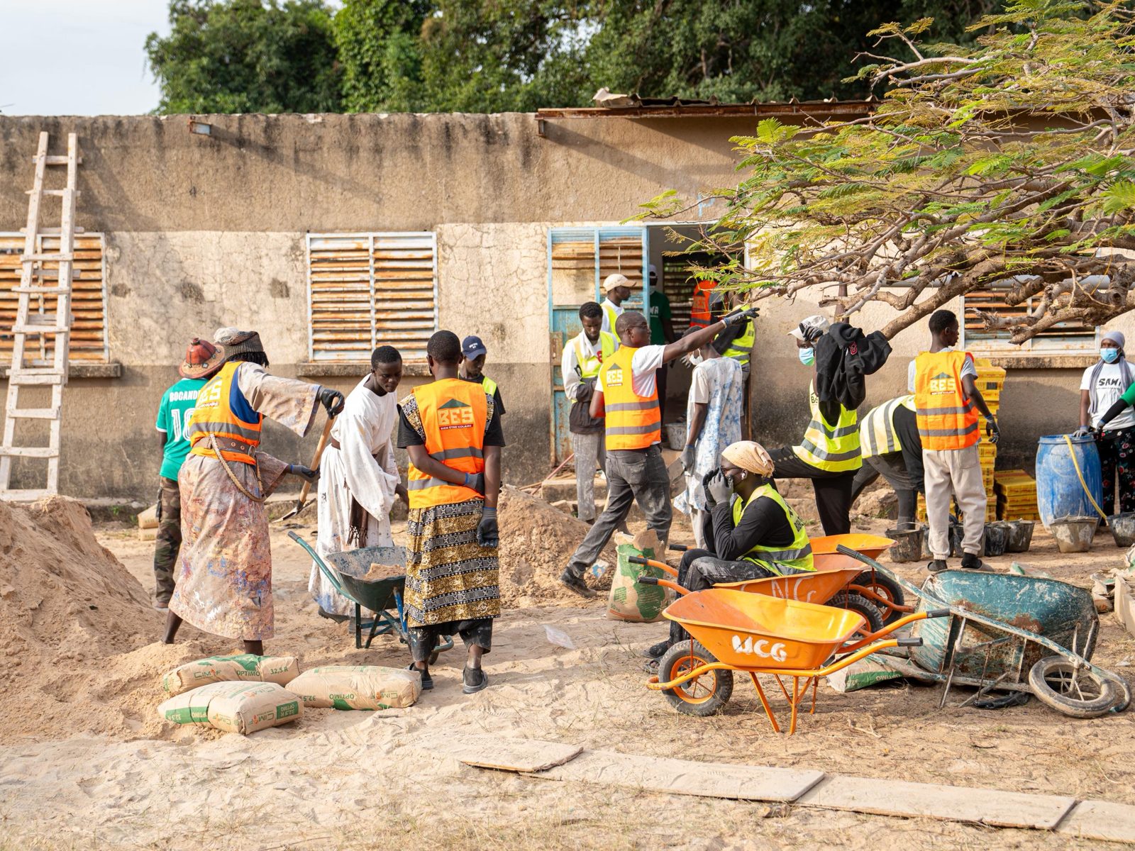 Bénévoles de la Team BÊS en gilets orange sur le chantier de rénovation d'une école